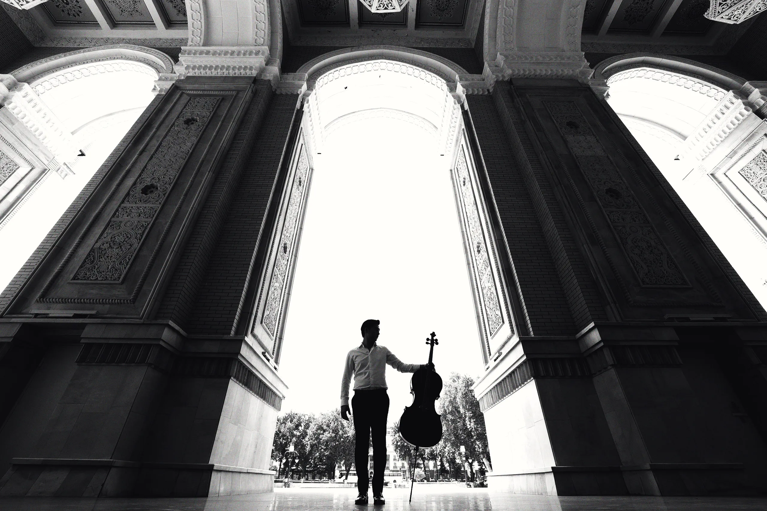 Dilshod Narzillaev with his cello in a great arched portal